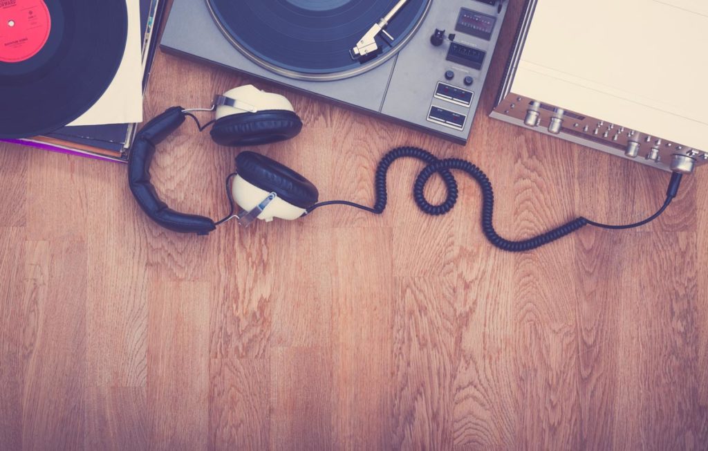 Record players headphones amplifier and vinyl sitting on a wooden floor