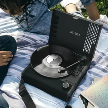 Two people playing a vinyl album on Victrola Revolution Go Record Player in Black colour.